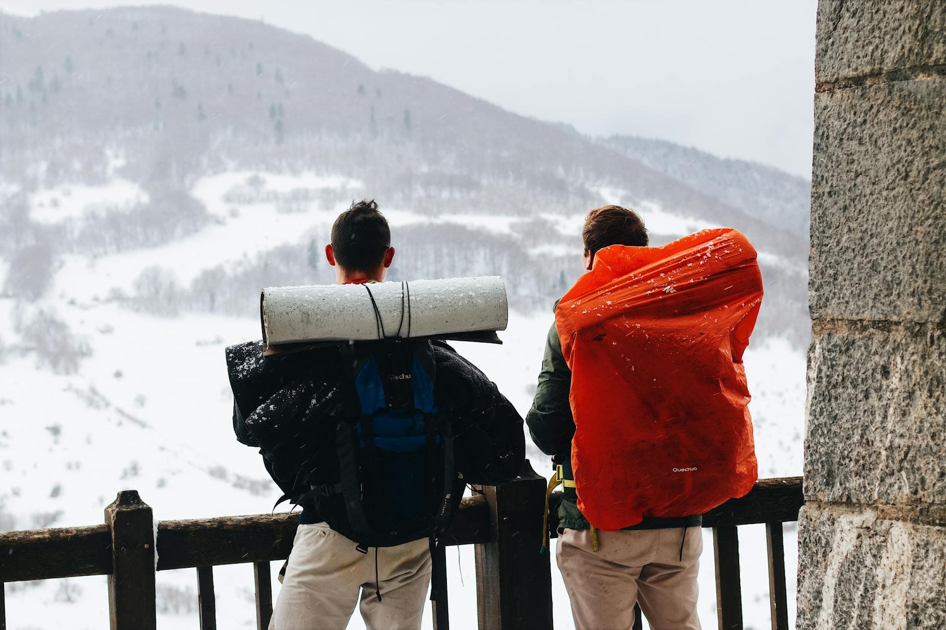 Vandrare med ryggsäck på väg mot snötäckt fjäll